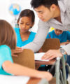 primary school educator helping a student in class